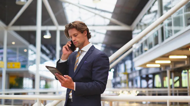 businessman-using-digital-tablet-while-talking-mobile-phone businessman-using-digital-tablet-while-talking-mobile-phone